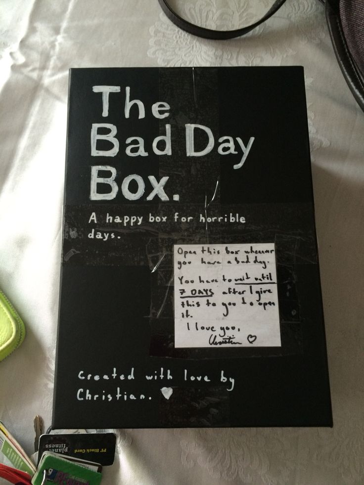 the bad day box is sitting on a bed next to some other items and books