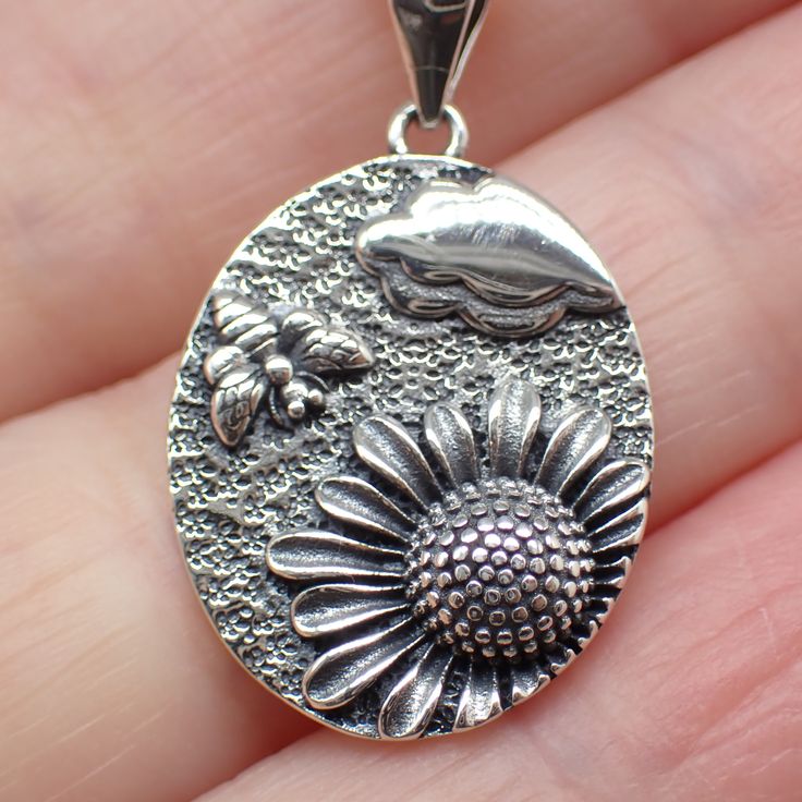 This sterling silver sunflower with bee charm works great as a necklace or on a charm bracelet. 27mm long including jump ring 22mm wide We recommend a 1mm chain which is sold separately here. Product highlights: Made from 925 sterling silver. Comes in a black cotton filled jewelry box making it easy for gifting. Long Lasting & Worry Free. This item is solid sterling silver and is not plated or filled. Wear it in the shower, at the beach or wherever you go. Hypoallergenic Silver Jewelry With Flower Pendant, Hypoallergenic Silver Flower Pendant Jewelry, Sterling Silver Flower Charms Jewelry, Silver Sunflower Design Necklace For Gift, Silver Oval Jewelry With Flower Charm, Silver Necklace With Sunflower Design For Gift, Silver Sunflower Pendant Jewelry, Sterling Silver Charms Jewelry In Flower Shape, Silver Jewelry With Sunflower Design Flower Pendant