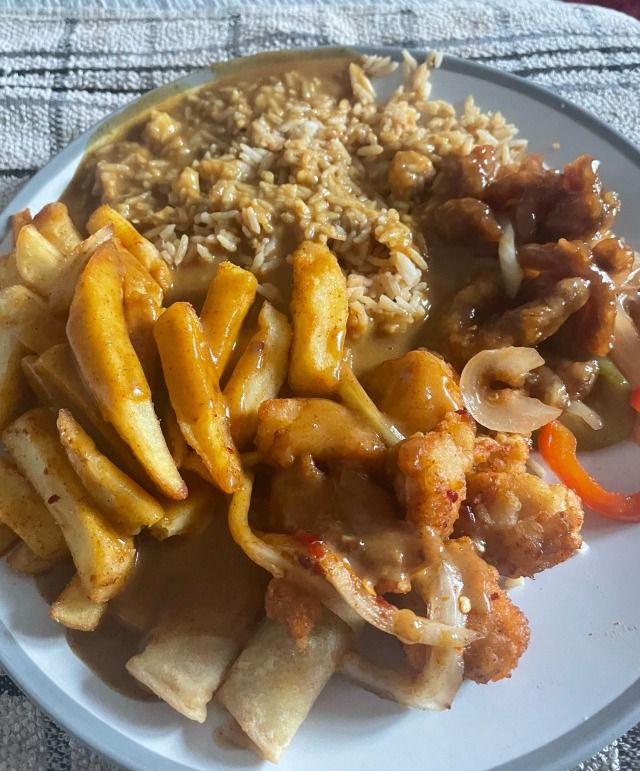 a white plate topped with meat and veggies covered in sauce next to rice