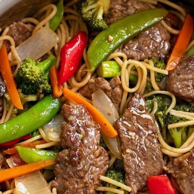 stir fry with beef, broccoli, peppers and carrots in a pan