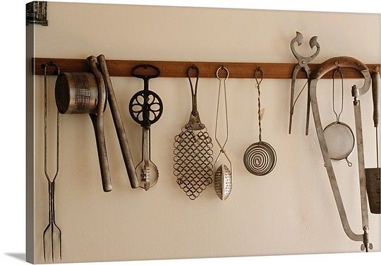 an assortment of kitchen utensils hanging on a wall