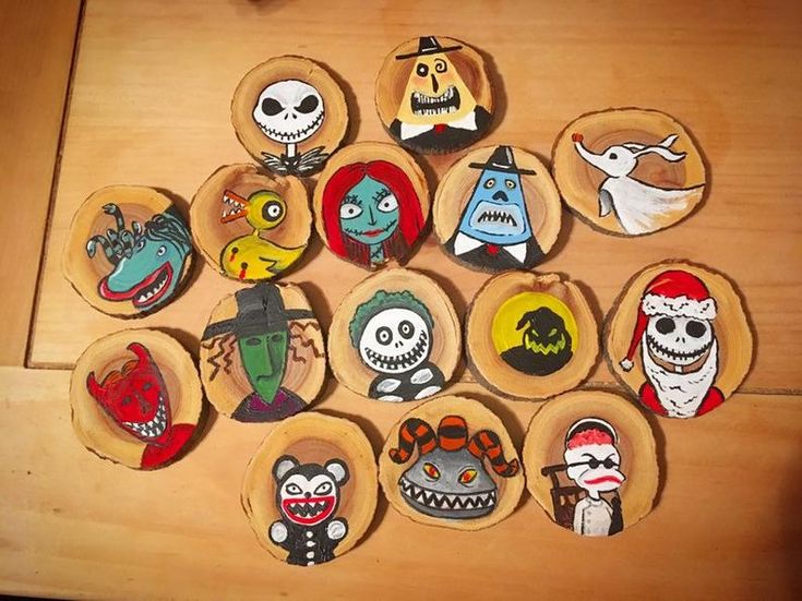 twelve halloween magnets are arranged on a wooden surface