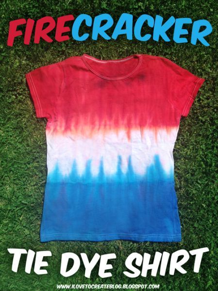 a red, white and blue tie dye t - shirt laying on top of green grass