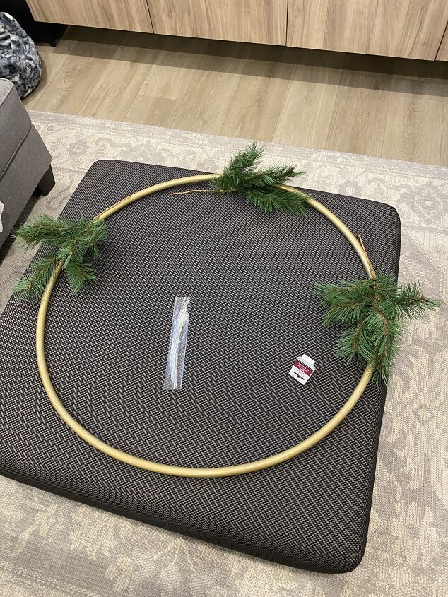 a circle made out of rope and pine branches on top of a rug in a living room