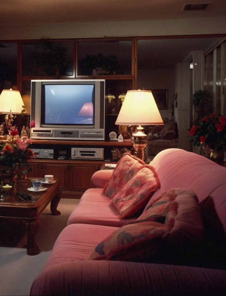 a living room filled with furniture and a flat screen tv on top of a wooden table