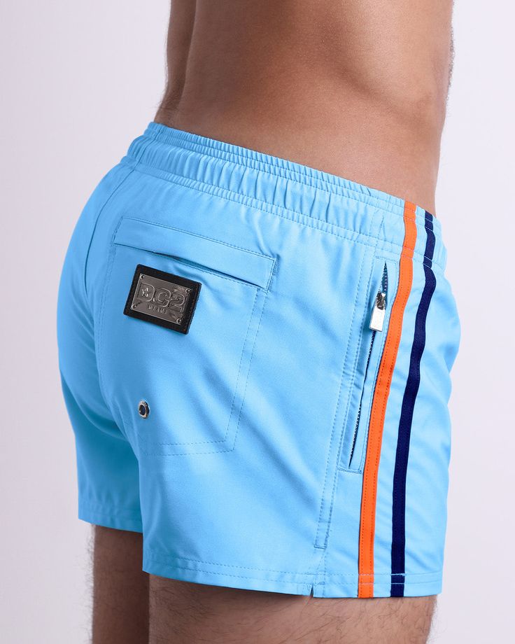 These new kids on the block are the direct cousins of our signature Show Shorts by BANG!® but with some bonus details that make them ideal for poolside leisure. Cut with the same shorter-leg length, so that your quads look their best. But these shorts have fully closeable pockets to keep all your items secure, with metallic zippers in shiny silver. The back pocket is also secured with another metallic zipper. You can think of these as vintage rugby or volleyball shorts but with an upgrade to ste Volleyball Shorts, Gym Tank Tops, New Kids On The Block, Coastal Blue, Tailored Shorts, Kids On The Block, Beach Tops, Jogger Shorts, Gym Shirts