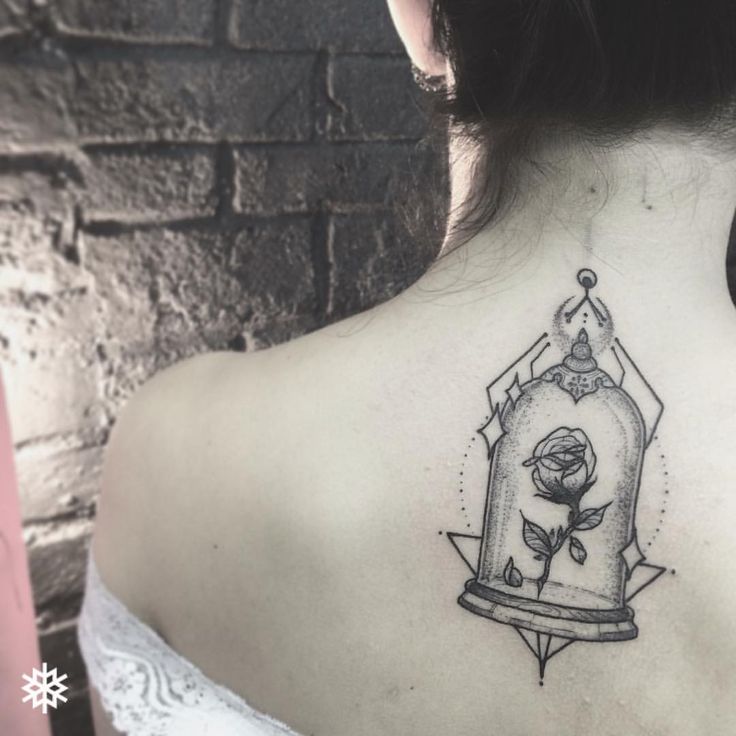 the back of a woman's neck with a bird in a cage tattoo on it