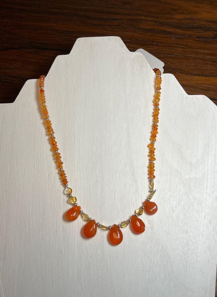 Carnelian with a happy looking orange!  The color is good any time of the year, but during especially Fall.  It is accompanied with citrine and Sterling silver beads.  It's also a good to wear when your favorite football or baseball team is playing. Assuming that team uses orange.   The necklace is 17 inches long. The toggle clasp at the back is silver plated.  The beads are 10mm x 15mm to 11mm x 10mm. Orange Carnelian Polished Beads Necklace, Orange Gemstone Beads And Cabochons As Gifts, Orange Gemstone Beads And Cabochons For Gifts, Orange Carnelian Gemstone Necklace, Orange Carnelian Beaded Necklace For Gift, Orange Carnelian Necklace In Spiritual Style, Carnelian Amber Beaded Gemstone Necklace, Amber Carnelian Beaded Necklace With Gemstone, Orange Citrine Gemstone Necklace