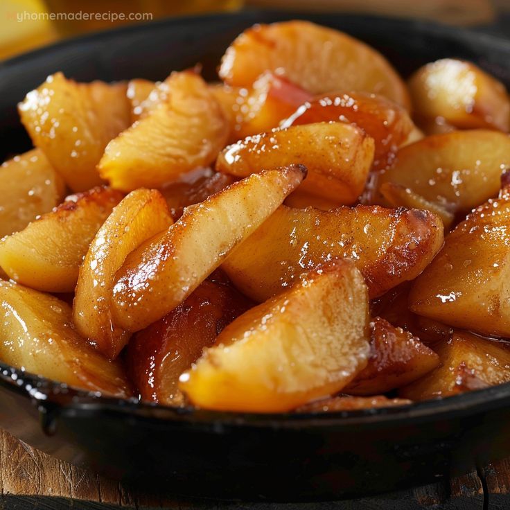 a black bowl filled with sliced apples on top of a wooden table