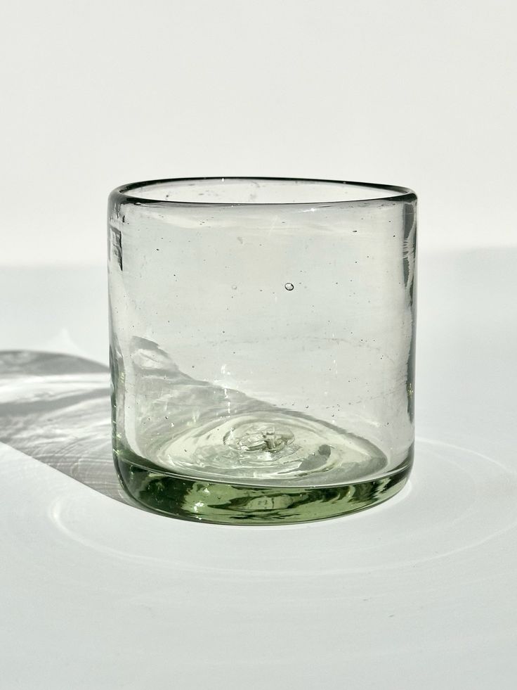 an empty glass sitting on top of a white table