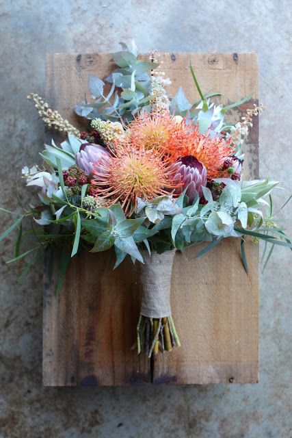 a bouquet of flowers sitting on top of a wooden board