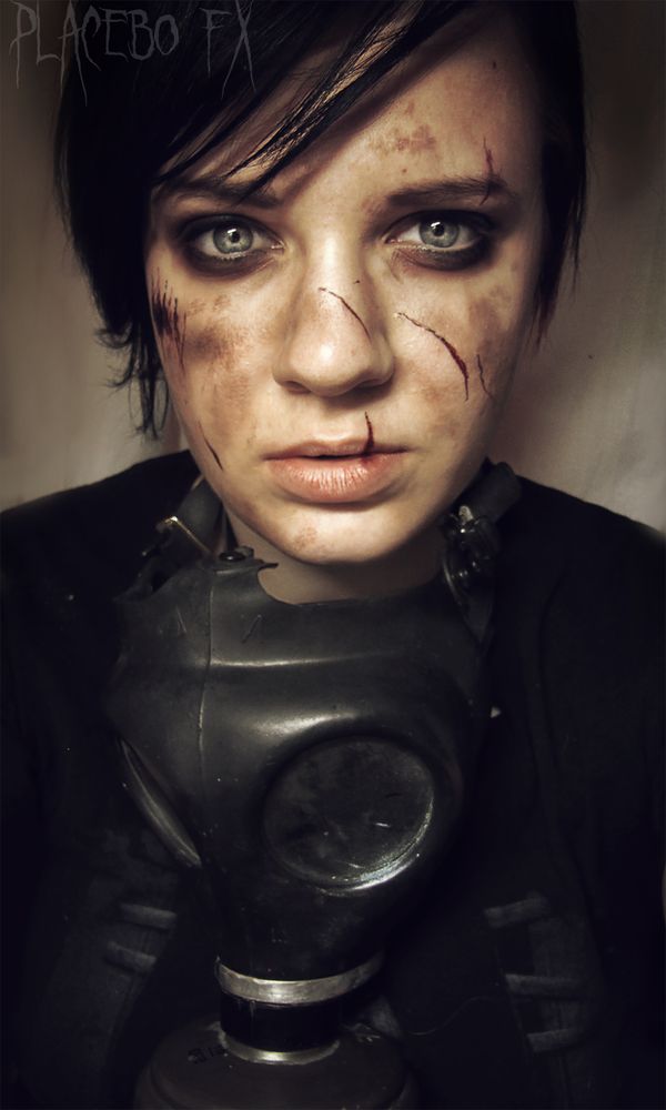 a woman wearing a gas mask with blood all over her face and eyeliners