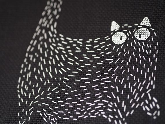 an animal made out of white thread on black fabric