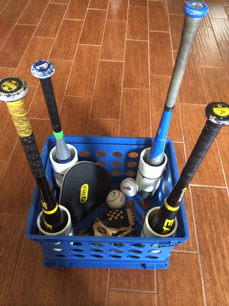 a blue basket filled with different types of baseball bats