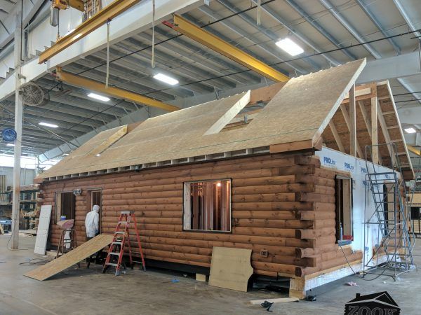 a small log cabin being built in a warehouse