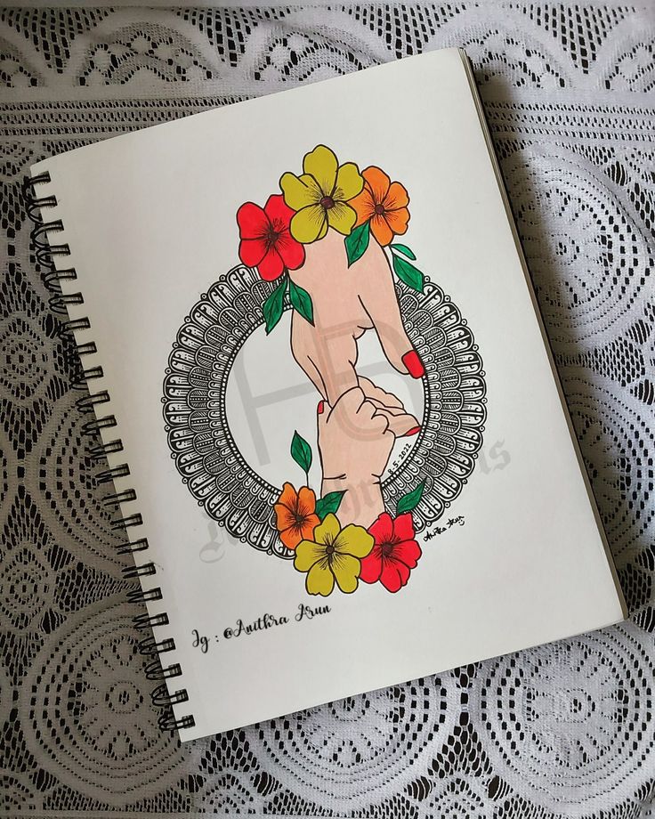 a drawing of a hand holding a wreath with flowers in the middle on top of a doily