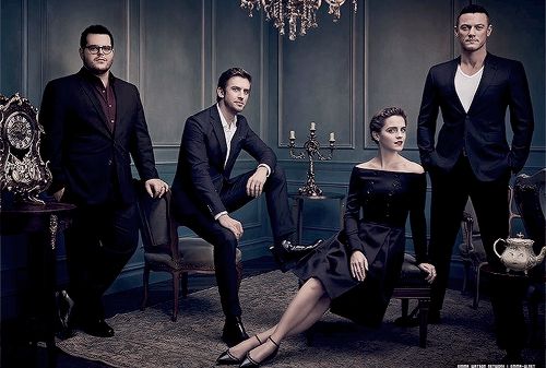 three men and two women posing for a photo in a room with chandelier