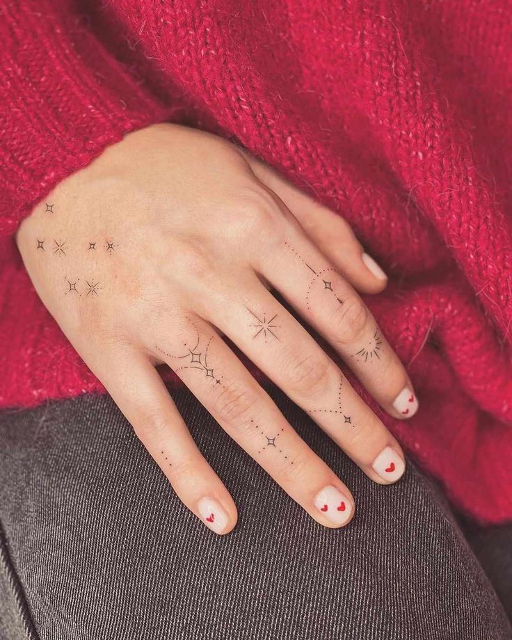 a woman's hand with stars on her left wrist and red sweater behind her