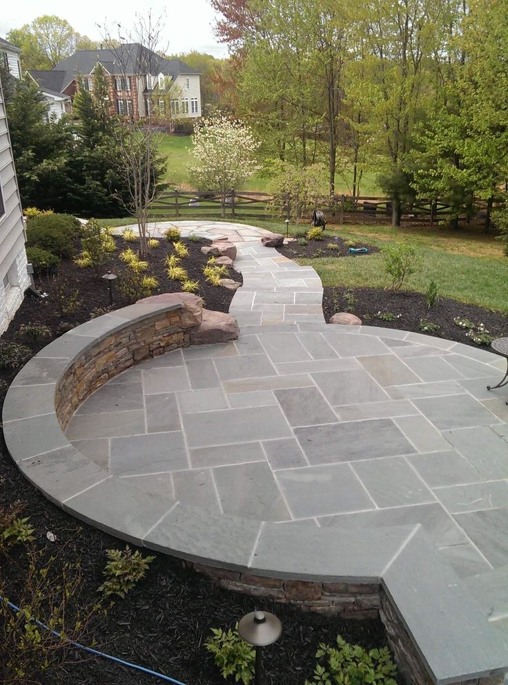 a stone walkway in the middle of a yard