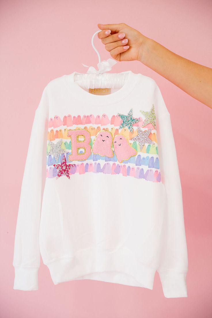 Get ready to spook up some fun with our MINI KIDS STAR GHOULS PULLOVER! This white pullover features a vibrant rainbow striped ghosts design and playful pink letters B and pink ghosts as O's that spell "Boo". Complete with colorful resin star patches, this pullover is perfect for your little one to show off their unique and quirky style. It's a boo-tiful addition to any wardrobe! All orders are currently shipping within 14 business days. To receive item quicker, expedited shipping is available a Star Patches, People Eater, Boo Tiful, Pink Letters, Quirky Style, White Pullover, Pink Letter, Ghost Design, Letter B