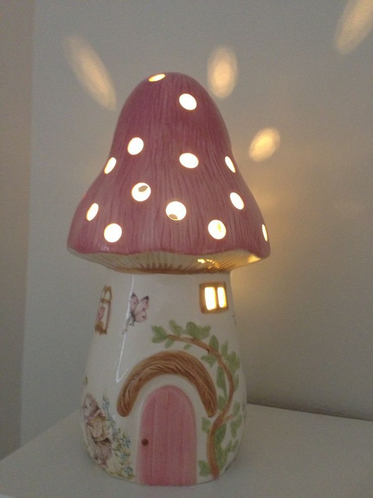 a pink mushroom shaped light sitting on top of a white shelf next to a wall