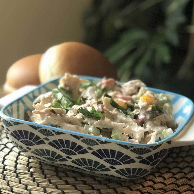 a blue and white bowl filled with food on top of a table