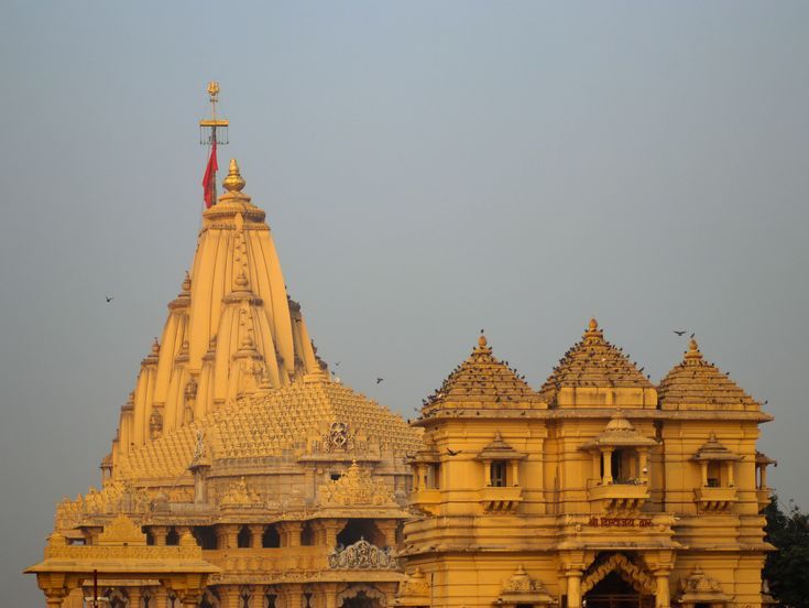 an ornate yellow building with birds flying around it