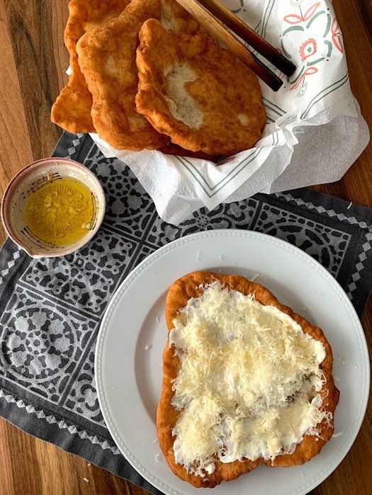 two pieces of bread with cheese on top and some mustard in a bowl next to it