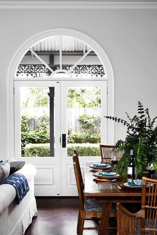 a living room with a couch, table and chairs next to an open door that leads to a patio