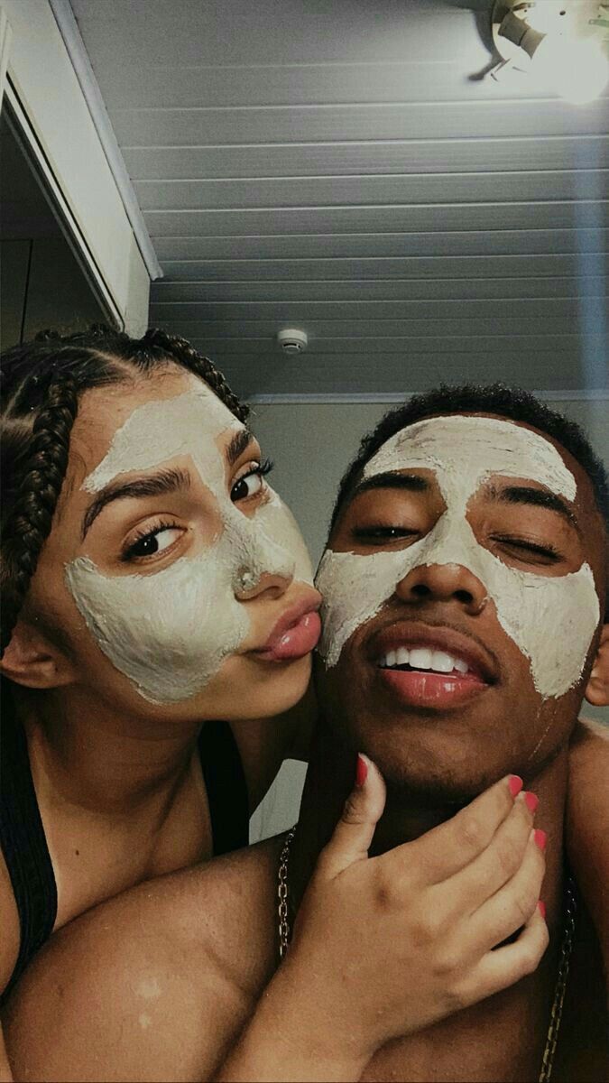 two people with facial masks on their faces are posing for the camera while one person holds his face up in front of him