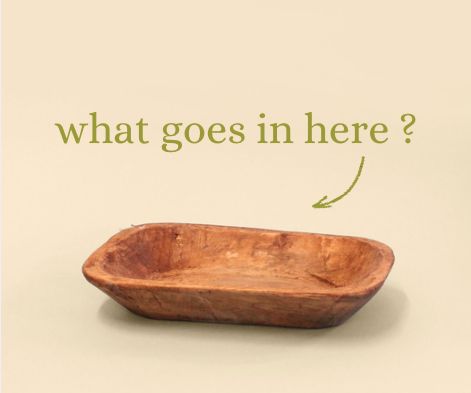 a wooden bowl with the words what goes in here? and an arrow pointing to it