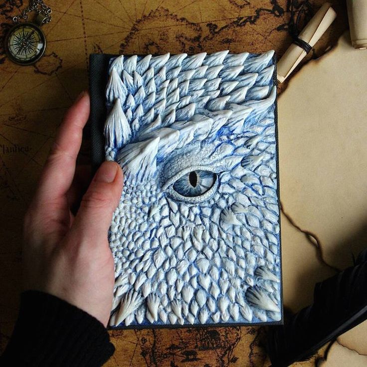 a person is holding a piece of paper with an owl's eye on it