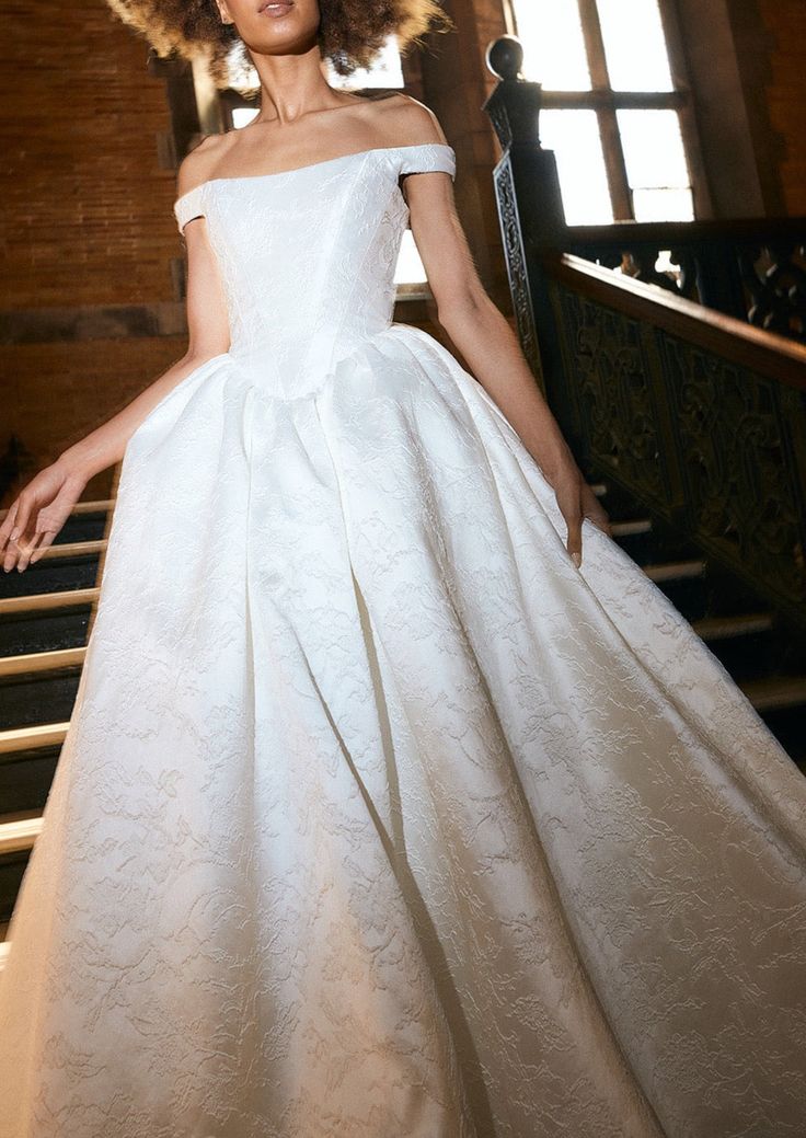 a woman in a white dress standing on stairs