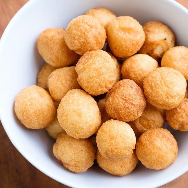 a white bowl filled with fried food on top of a wooden table