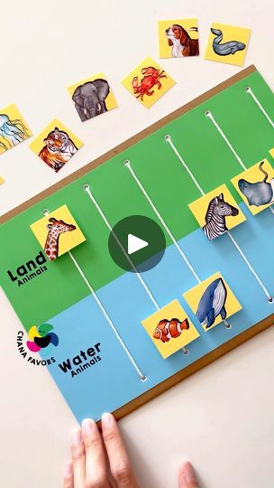 a board game with animals on it being held up by someone's hands while they play