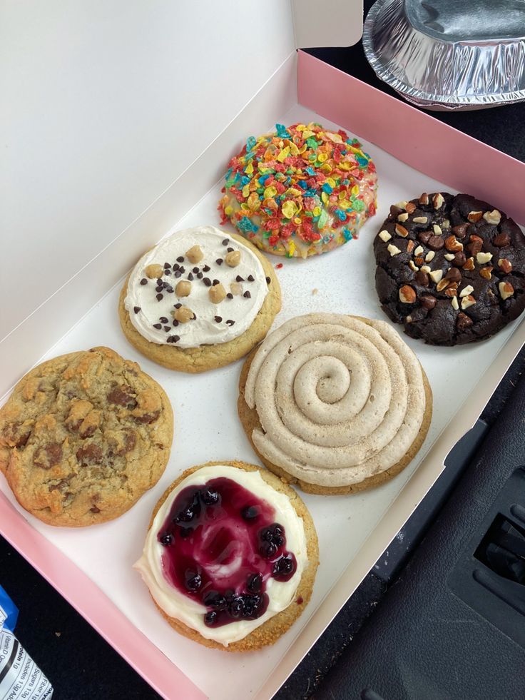 a box filled with lots of different types of doughnuts and muffins