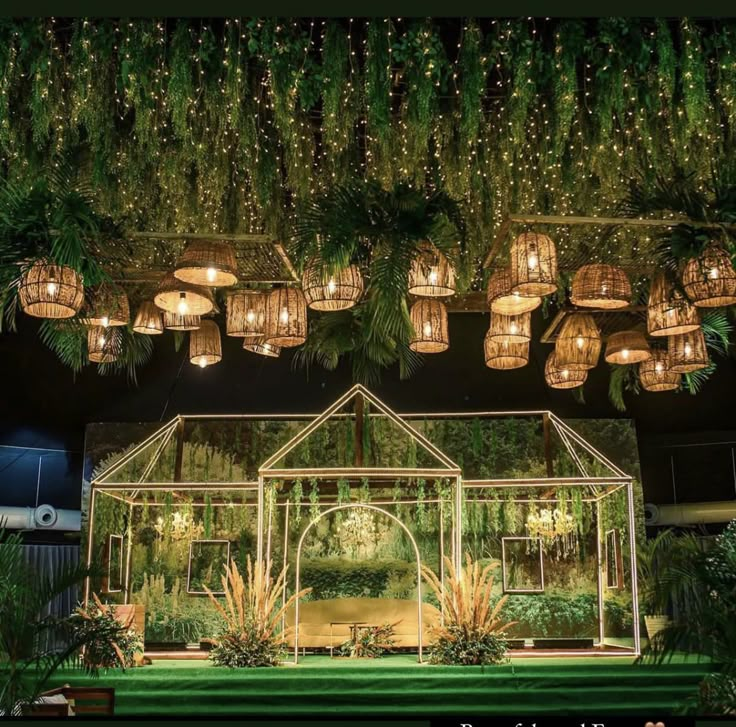 an outdoor wedding venue with lots of lights and greenery