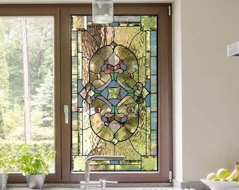 a kitchen with a large stained glass window in the center and sink below it,