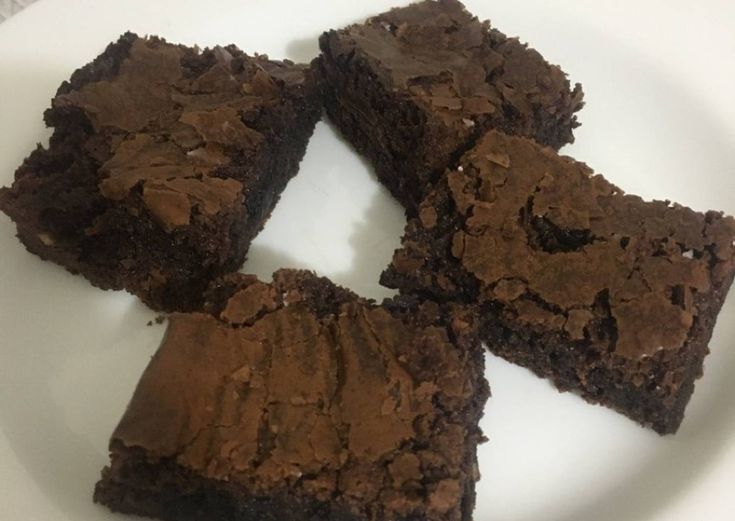 four pieces of brownie on a white plate