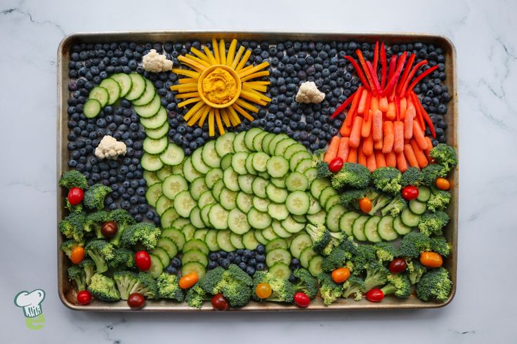 a tray with broccoli, carrots, cucumbers and other vegetables