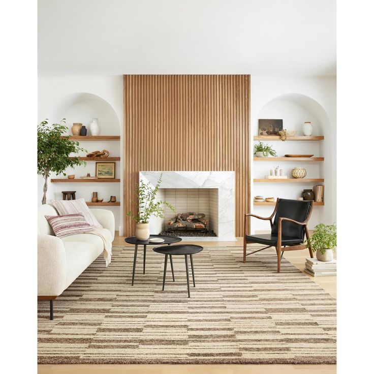 a living room filled with furniture and a fire place in front of a wall mounted fireplace