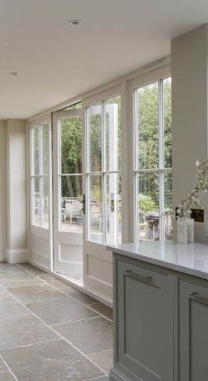 an empty kitchen with large windows and tile flooring