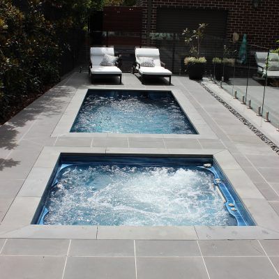 an outdoor jacuzzi with two lounge chairs next to it