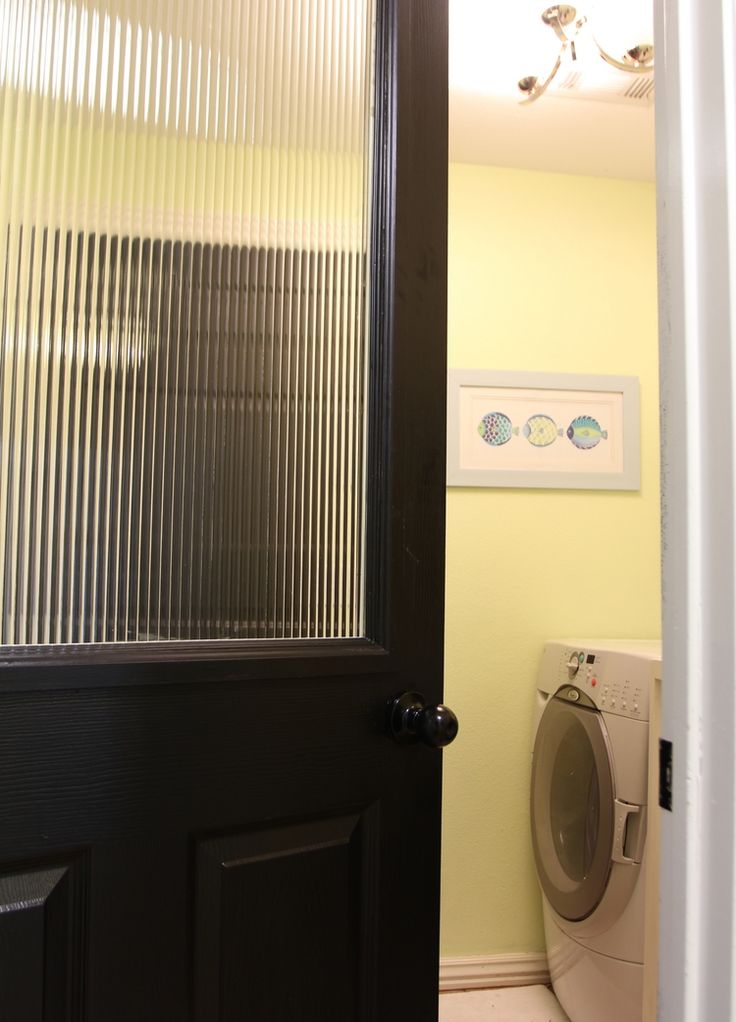 a bathroom door is open to reveal a washer and dryer in the room