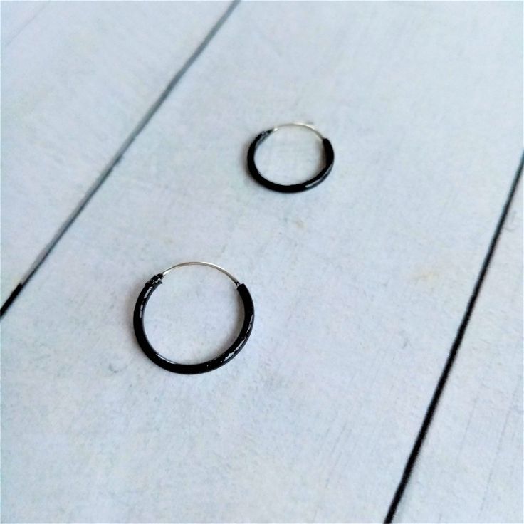 Black Hoop Earrings made by Silver Sterling 925. You can choose Size: - 10mm diameter x 1,2mm - 12mm diameter x 1,2mm - 14mm diameter x 1,2mm The black color is achieved by enameling silver with Ruthenium. In the seafaring tradition, the number of rings a sailor wore indicated the voyages he had completed. 1 hoop Cape Horn, 2 Cape of Good Hope, 3 Hoops around the world. Our earrings are sent in wooden boxes silk-screened by us, the boxes are made of recycled wood from the North of Galicia (Spain Black Minimalist Sterling Silver Cartilage Earrings, Small Black Hoop Earrings For Everyday, Minimalist Black Hoop Cartilage Earrings, Minimalist Black Cartilage Earrings With Ear Wire, Black Minimalist Small Hoop Earrings, Minimalist Black Round Cartilage Earrings, Everyday Black Single Hoop Earring, Everyday Small Black Hoop Earrings, Black Sterling Silver Hoop Earrings For Everyday