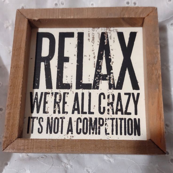 a sign that says relax we're all crazy it's not a competition