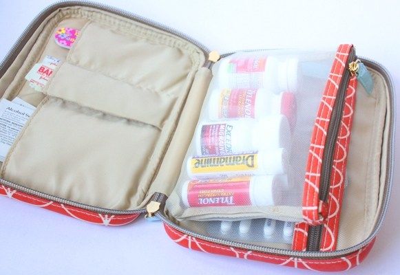 an open red and white suitcase filled with toiletries on top of a white table