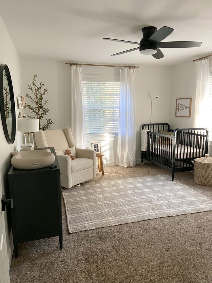 a baby's room with a crib, chair, and couch in it