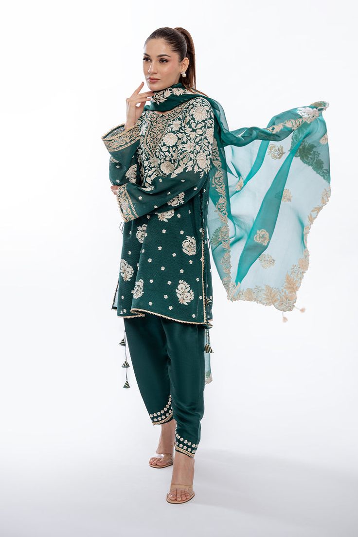 A short emerald green khaddi corduroy shirt with aari and tilla embroidery is paired with a matching worked organza dupatta. Playful tassel detailing complements the shirt and an embroidered rawsilk shalwar completes the look. Model Height is 5'6 and Shirt Length is 35' Embroidered Green Cotton Silk Anarkali Set, Green Cotton Silk Kurta With Sheer Dupatta, Designer Green Dupatta For Transitional Season, Traditional Green Kurta With Sheer Dupatta, Green Cotton Silk Traditional Wear With Resham Embroidery, Green Unstitched Cotton Silk Sharara, Unstitched Green Cotton Silk Sharara, Unstitched Green Sharara In Cotton Silk, Green Cotton Silk Sets With Dabka Detailing