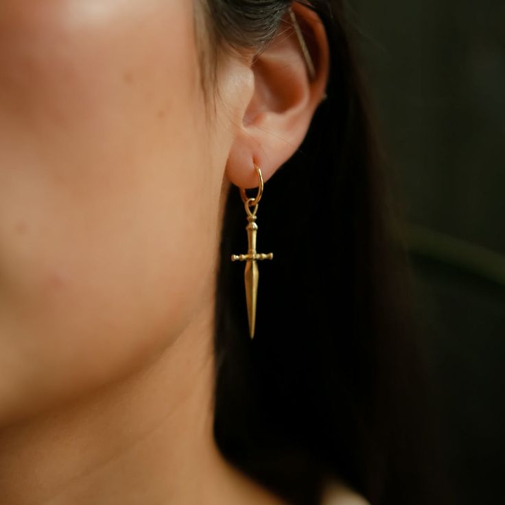 A symbol of protection these knife earrings will add a little fierce-ness to your day. Pair these beauties perfectly with our Marceline Necklace in 14k Gold, Brass, or Silver. FEATURED IN BRITISH VOGUE "Cival is a collective of women who design, and hand make jewelry that inspires creativity and confidence. As a symbol of protection, our 'Marceline' earrings are a nod to our fierce side, embodying bravery, and strength." - British Vogue September 2021 Issue Materials & Details Knife charm measur Marceline Necklace, Queer Earrings, Earring Styling, Gothic Dangle Pierced Earrings, Punk Earrings Gothic Jewelry, Knife Jewelry, Dagger Earrings Regalrose Jewellery, Swords Earrings, Knife Earrings